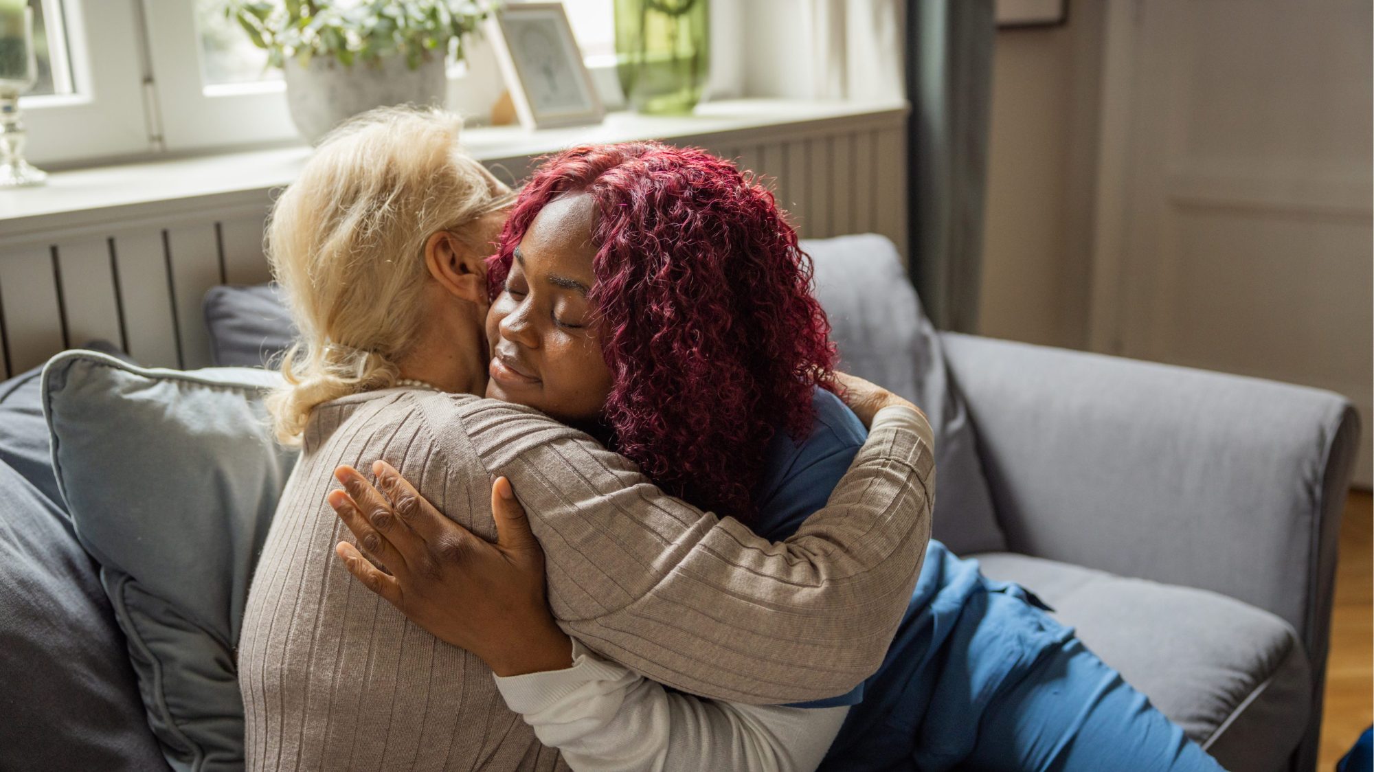 Women embracing a senior citizen